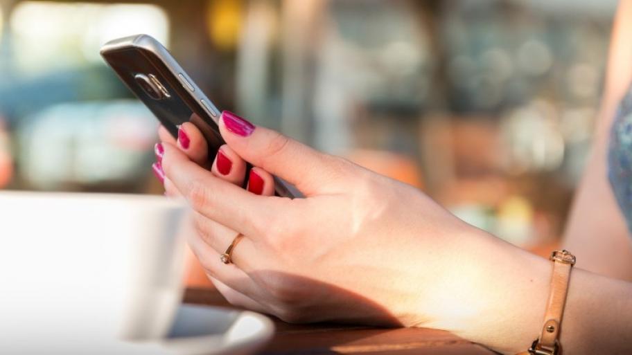 Mädchen, das ein Handy in der Hand hält 