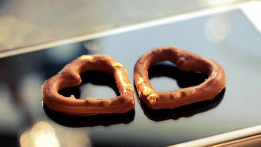 Zwei Salzbretzeln in Herzform liegen auf Handybildschirm