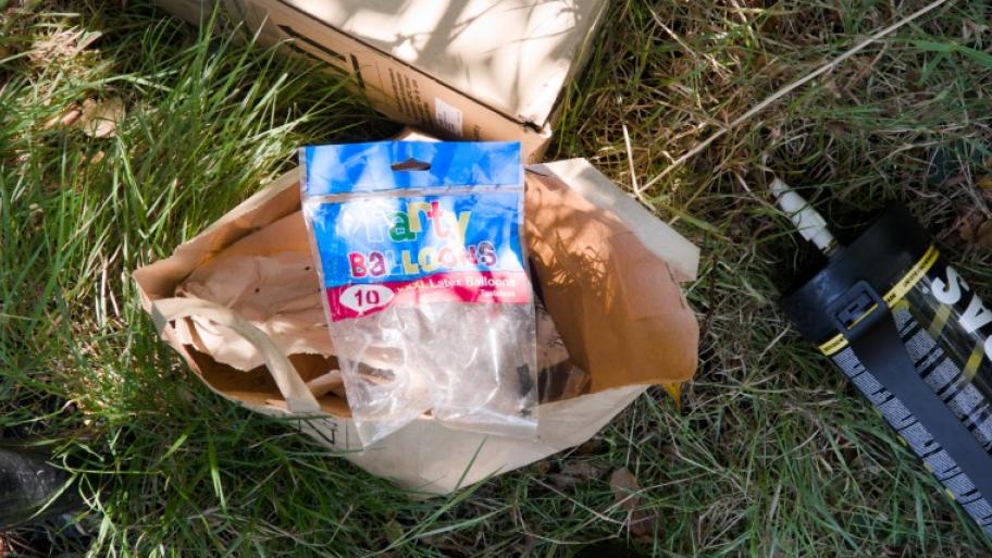 Eine Packung Luftballons. Daneben liegt eine Flasche Lachgas.