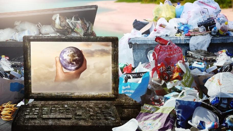 Man sieht im Vordergrund einen grauen, mit Moos bewachsenen, heruntergekommenen Laptop. Auf dem Display des Laptops ist eine Hand, die die Erdkugel hält, abgebildet. Im Hintergrund und daneben türmen sich Berge an Müll.
