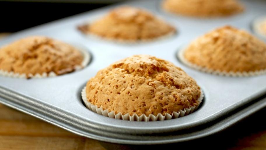 in einer metallenen Muffin-Backform mehrere fertige helle Muffins