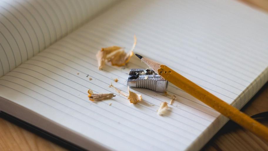 Angespitzter Bleistift und leeres Buch