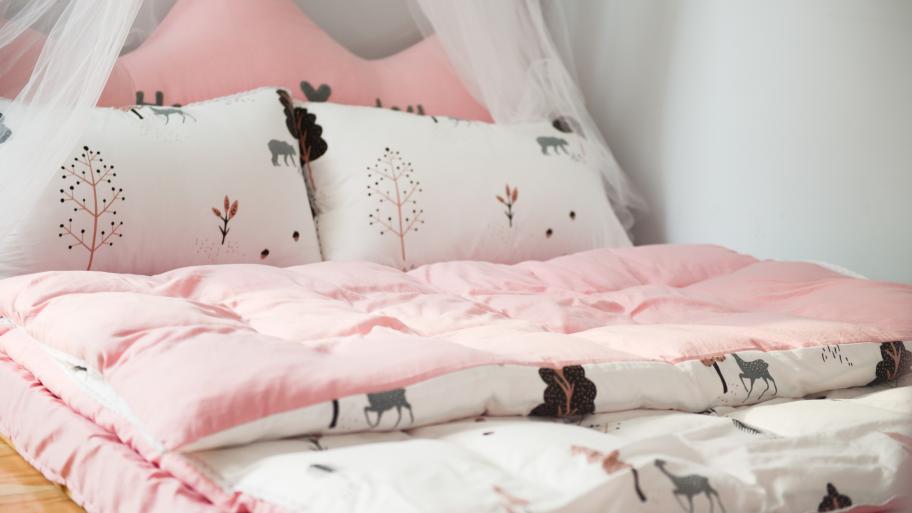 Bett mit rosa-weißer Bettwäsche