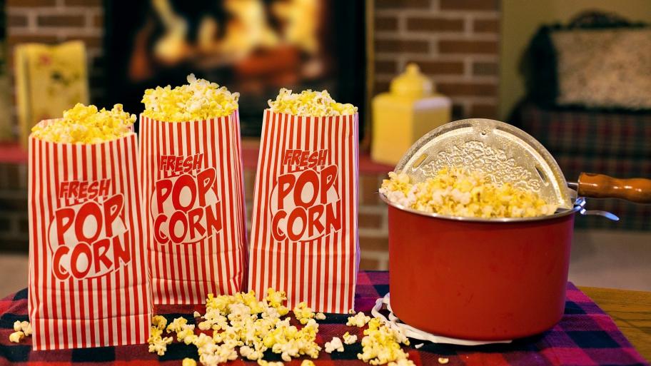 Mehrere Popcorntüten vor einem Kaminfeuer. 