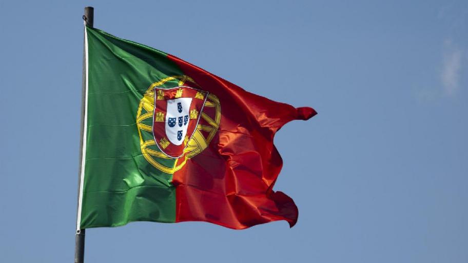 Die portugiesische Flagge weht in blauem Himmel. Sie ist grün und rotfarbig.