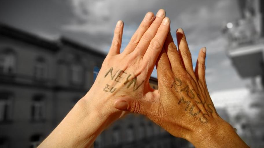 zwei Hände berühren sich, auf denen steht "Nein zu Rassismus"
