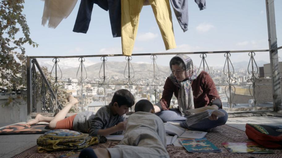 Auf der Terasse in Teheran sitzen zwei Jungs und ihre Mutter über Schulbüchern.