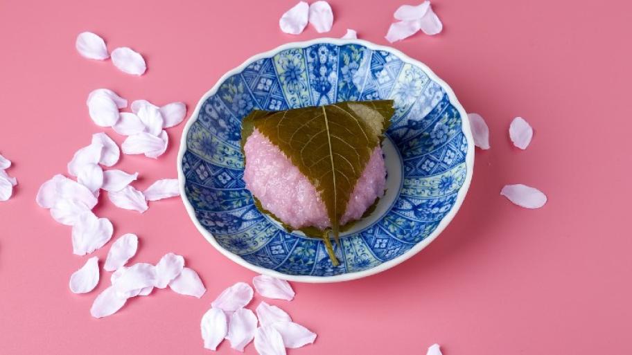 Ein japanischer Snack. Eine Art süßes Reisbällchen, das mit einem Kirschblatt umwickelt ist.