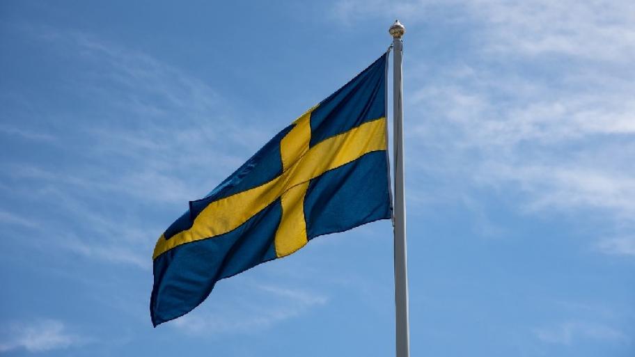 Zu sehen ist die schwedische Flagge vor einem blauen Himmel. 