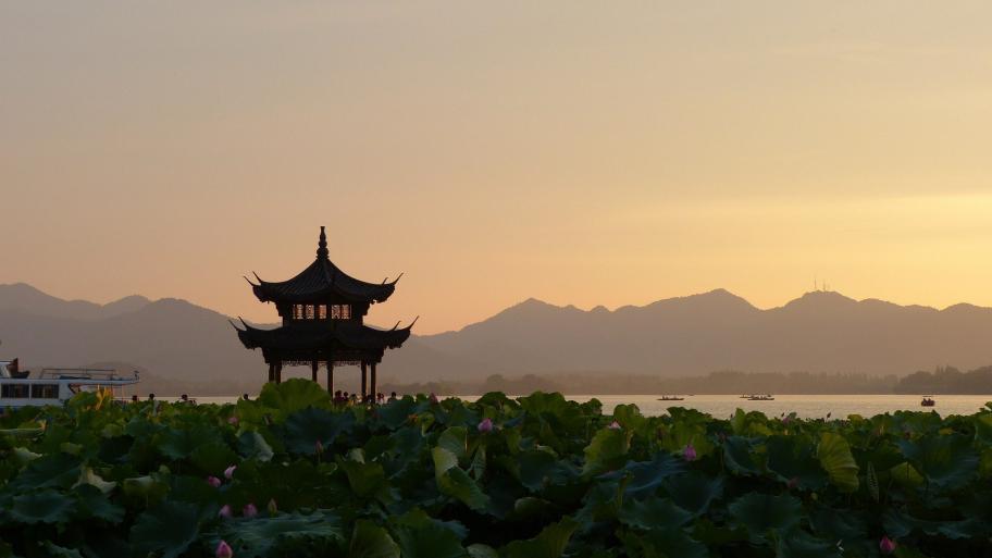 Chinesisches Teehaus in einer chinesischen Berglandschaft am Meer bei Sonnenuntergang