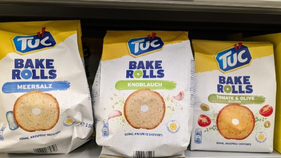 Drei Verpackungen der TUC Brotchips stehen in einem Supermarkt Regal 