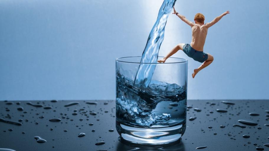 Kind springt in Wasserglas