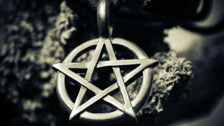 Zu sehen ist ein Pentagrammzeichen, dass an einer Kette hängt. 