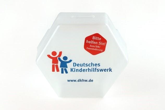 zu sehen ist die transparente, sechseckige Spendendose mit dem Logo vom Deutschen Kinderhilfswerk