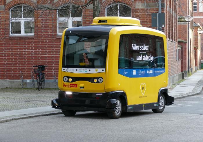 ein kleiner, gelber, autonom fahrender Busshuttle