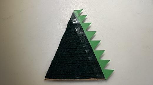 Papp-Dreieck, mit grüner Wolle umwickelt, grüner Zackenstreifen rechts