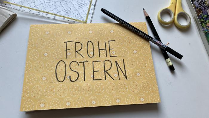 Die Außenseite der Karte dekoriert mit dem Spruch "Frohe Ostern".
