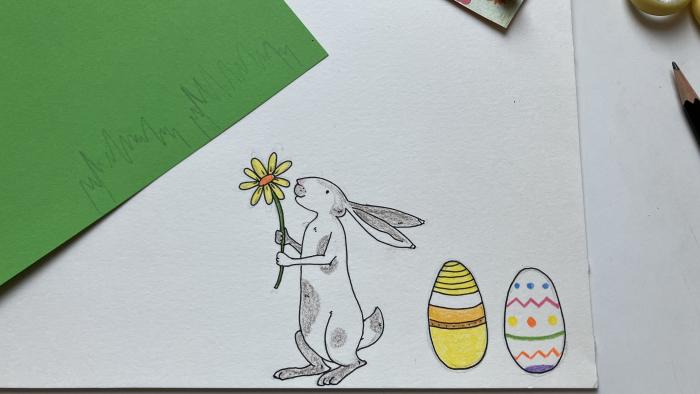 Ein gezeichneter Hase, Ostereier und Gras.