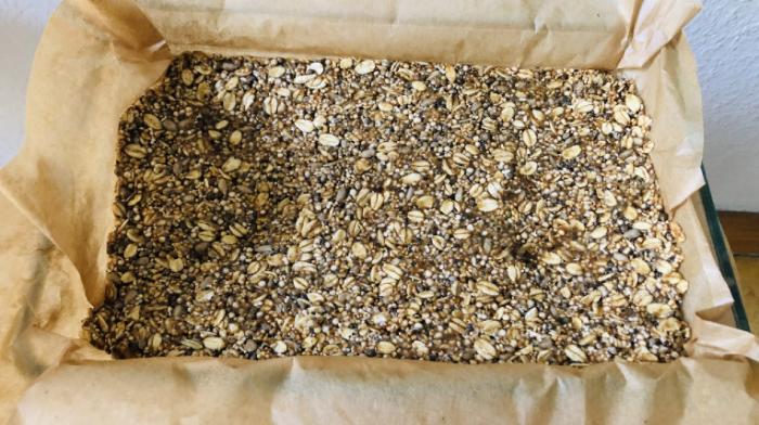 fertige Müsliriegel in mit Backpapier ausgelegter Auflaufform