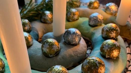 Adventsspirale angemalt mit grüner, silberner und goldener Tusche; Schokokugeln und Kerzen auf die 24 Löcher verteilt