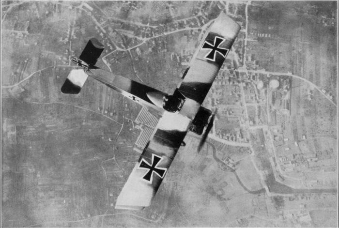 Deutscher Fokker-Kampfeinsitzer (Doppeldecker) während des 1. Weltkriegs im Flug über einer französischen Ortschaft
