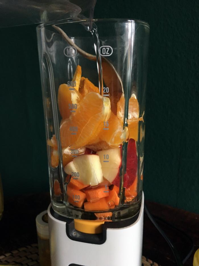 Obst für orangenen Smoothie im Mixer
