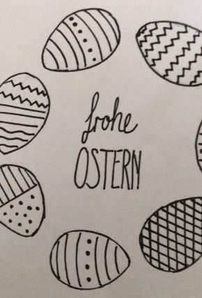 In der Mitte einer Osterkarte steht "frohe Ostern" in schwarzer Schrift. Die Worte stehen in einem Kranz aus Ostereiern.