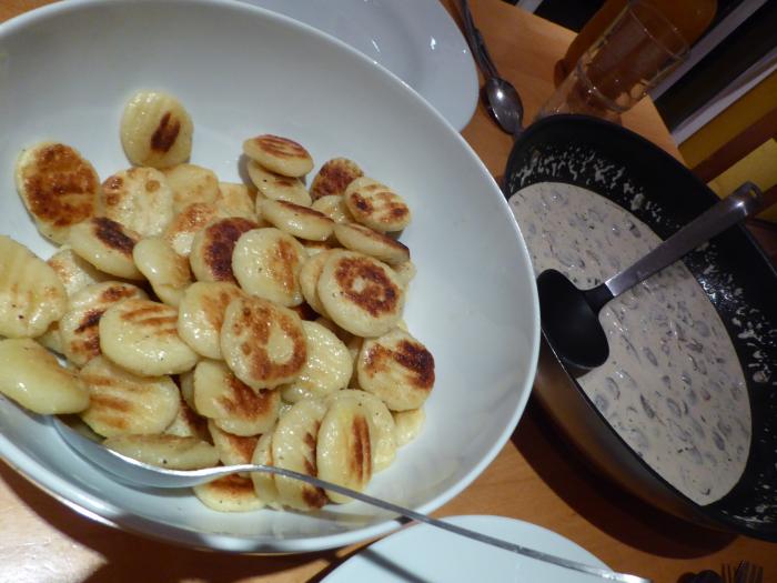 Angebratene Gnocchi werden auf einem Teller serviert; dazu gibt es eine Pilz-Sahne-Soße
