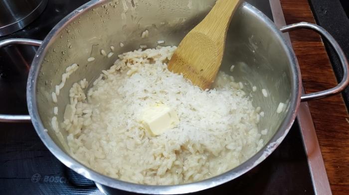 Parmesan mit Butter in den Topf mit Reis geben