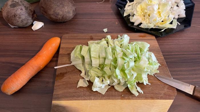 Weißkohl wird auf einem Brett geschnitten.