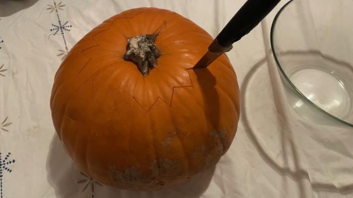 Ein Foto von einem Kürbis mit einem Messer.